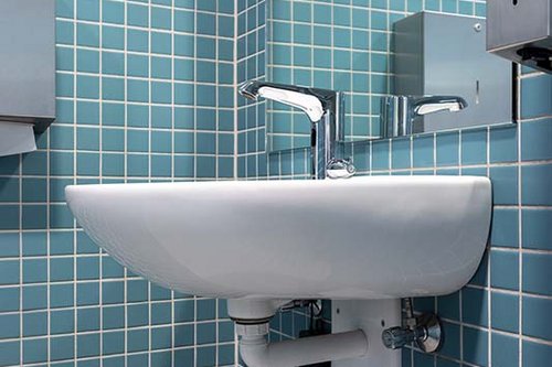 Seitliche Ansicht der Elektronischen Waschtisch-Armatur XERIS E-T HD-M mit darunter angeschlossenem SSC Bluetooth®-Modul in der KissSalis Therme