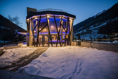 Beleuchtete Außenansicht des Restaurant Stochas im Schnee.