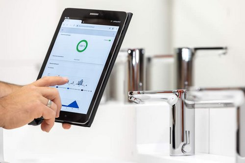 Tablet zeigt Spüldaten einer elektronischen Waschtisch-Armatur CELIS E in der Kita Spitzholz an.