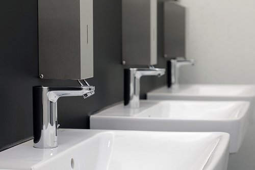 Schrägaufnahme von mehreren Waschtisch-Armaturen CELIS E HD-M im Sanitärraum der Freiburger Turnerschaft