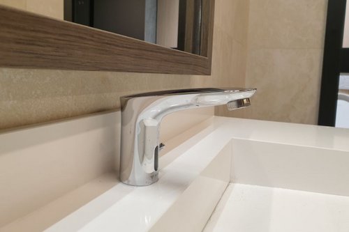 Nahaufnahme einer elektronischen Waschtisch-Armatur MODUS E HD-M in den Sanitärräumen des Boutique Fitnessstudios EVO Fitness Bel & Main in Wien.