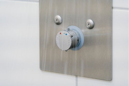 Nahaufnahme der Unterputz-Dusche LINUS Basic D-C-T mit laufendem Wasser in den Duschräumen der Dorfschule Ginderich.