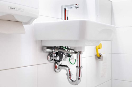 Elektronische Waschtisch-Armatur CELIS E auf und SWS Bus-Extender-Kabel unter dem Waschbecken in der Kita Spitzholz.