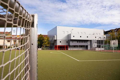 Fussballfeld-mit-Blick-auf-das-Gebaeude-des-TSV-Muenchen-Ost-e