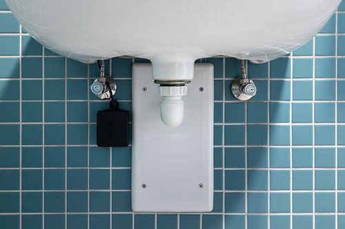 Frontalansicht des angeschlossenen SSC Bluetooth®-Modul unter einem Waschbecken in der KissSalis Therme mit Eckventil mit Regulierfunktion COMFORT mit Filter.