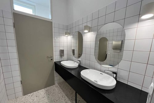 Die Sanitärbereiche des ActiCtiy Zentrum für Bewegung und Tanz mit den elektronischen Waschtisch-Armatur XERIS E HD-M large von SCHELL.