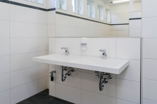 Zwei elektronische Waschtisch-Armaturen XERIS E HD-M in den Sanitärräumen der Dorfschule Ginderich.