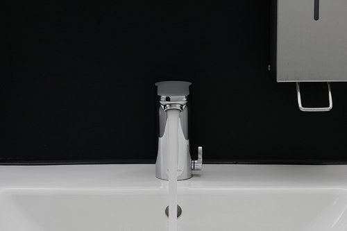 Elektronische Waschtisch-Armatur CELIS E HD-M  mit fließendem Wasser im Sanitärraum der Freiburger Turnerschaft.