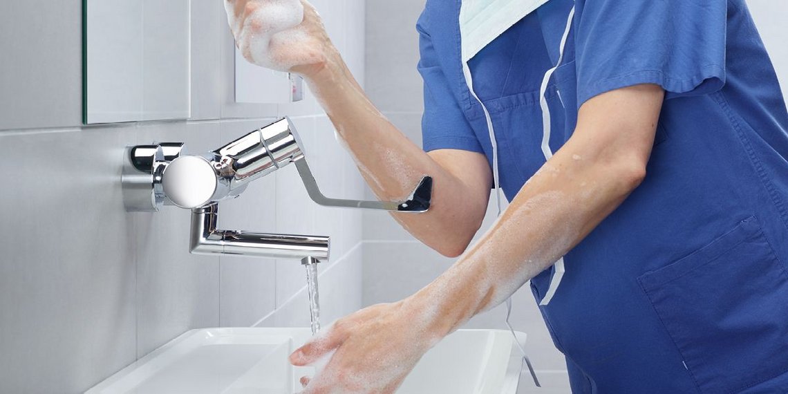 ine Krankenschwester wäscht sich die Hände an einer Waschtisch-Armatur VITUS mit Klinikarmhebel