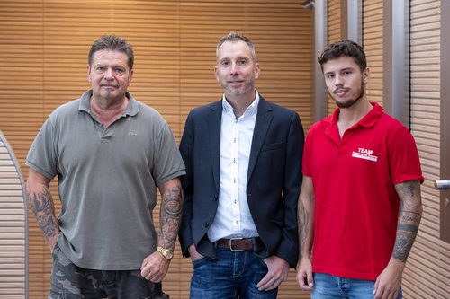 Sauna-Betreiber und SCHELL Mitarbeiter mit Duschpaneel LINUS Inox DP-C-T und Duschkopf COMFORT Flex in Panorama Sauna Grafschaft-Holzweiler