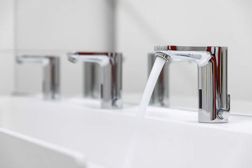 Elektronische Waschtisch-Armatur CELIS E mit laufendem Wasserstrahl in der Kita Spitzholz.