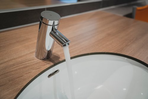 Selbstschluss-Waschtisch-Armatur PURIS SC von SCHELL mit austretendem Wasserstrahl