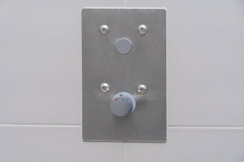 Die Betätigungsplatte der Unterputz-Dusche LINUS Basic D-C-T in den Duschen der Sporthalle der Gemeinschaftsgrundschule Theodor-Heuss in Wesel-Bislich.