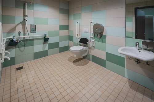 Elektronische Waschtisch-Armatur PURIS E und Unterputz-Dusche LINUS D-C-T im barrierefreien Sanitärbereich des Kursbeckens